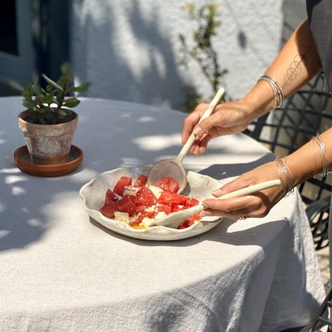 Plat de service Céleste en grès, fait main, avec une salade de pastèque et feta, en cours de préparation.