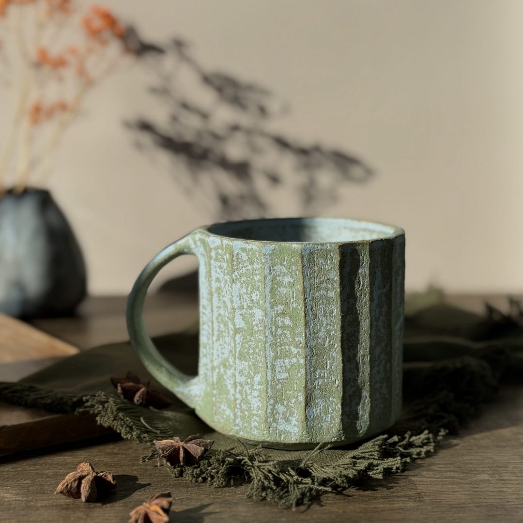 Grand mug KAITO sur une table avec une jolie lumière, façonné en céramique artisanale en grès.