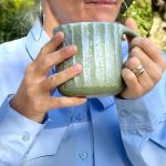 Mug Kaito en grès artisanal tenu en main, céramique faite main, tasse artisanale pour café ou cappuccino.