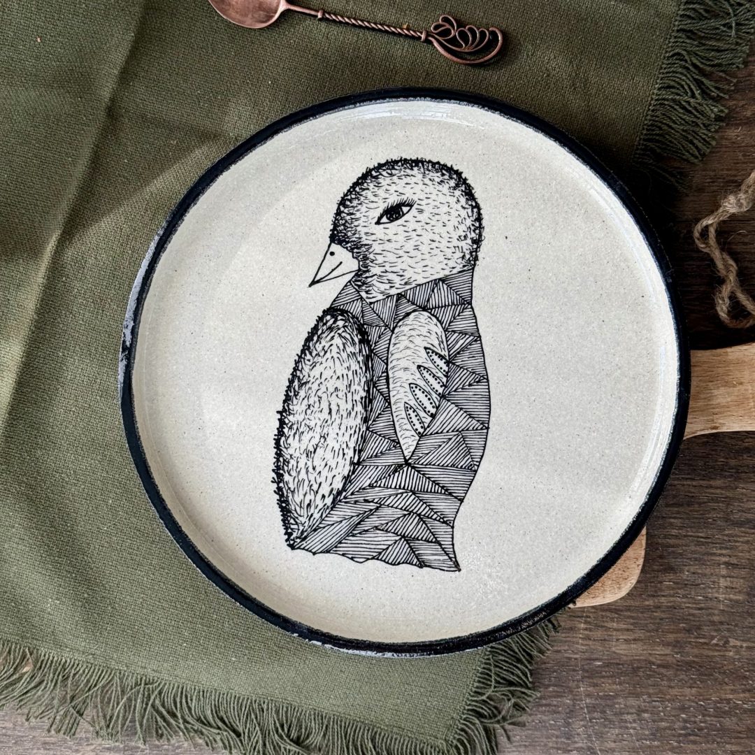 L'assiette LE PINGOUIN en céramique artisanale sur une table.
