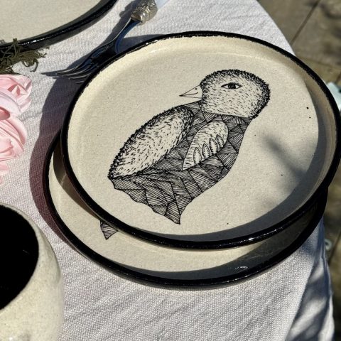 Assiettes LE PINGOUIN en grès blanc chamotté posées en pile sur une table