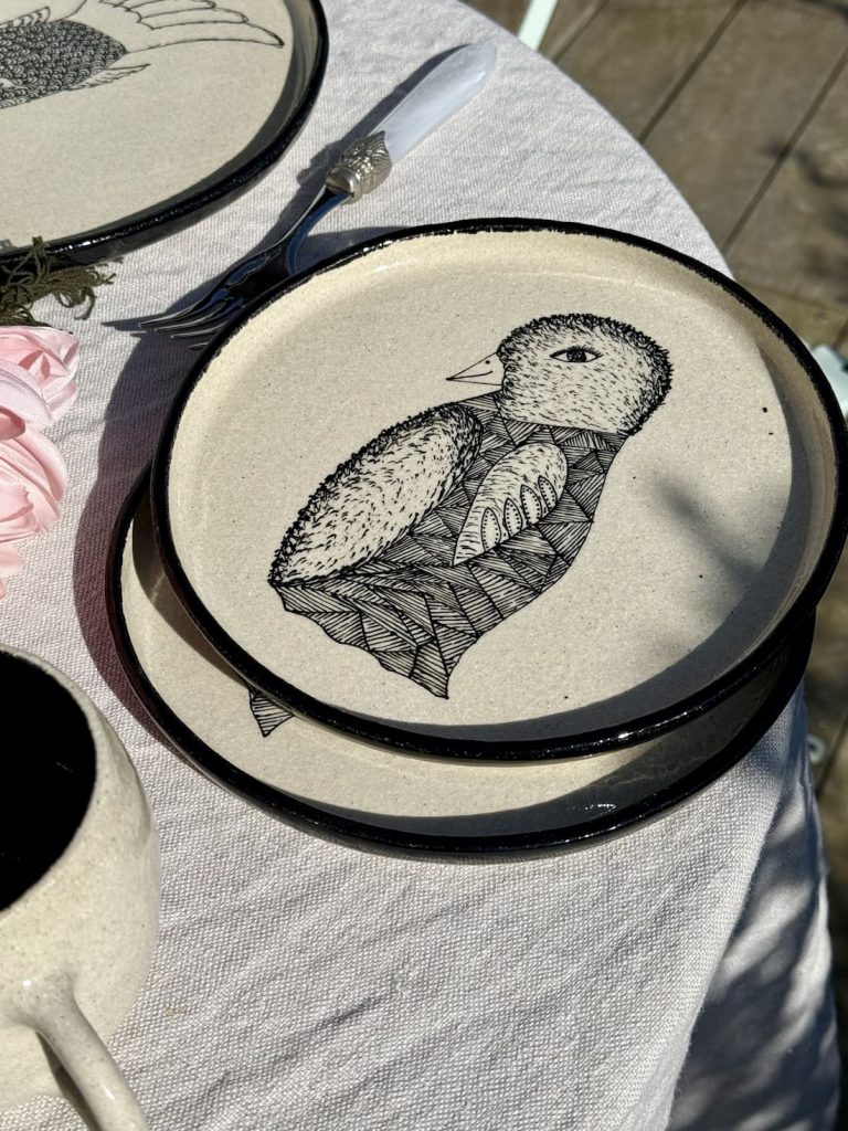 Assiettes LE PINGOUIN en grès blanc chamotté posées en pile sur une table