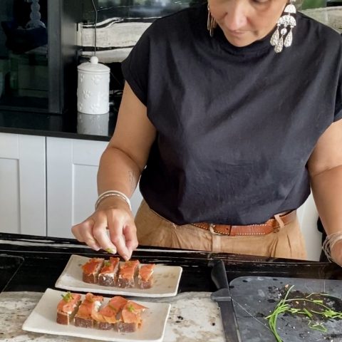 Préparation en cuisine de toasts au saumon sur les plats étoile en grès artisanal.