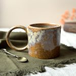 Mug GARANCE en grès artisanal vu de profil, posé sur une table dressée avec une cuillère à côté.