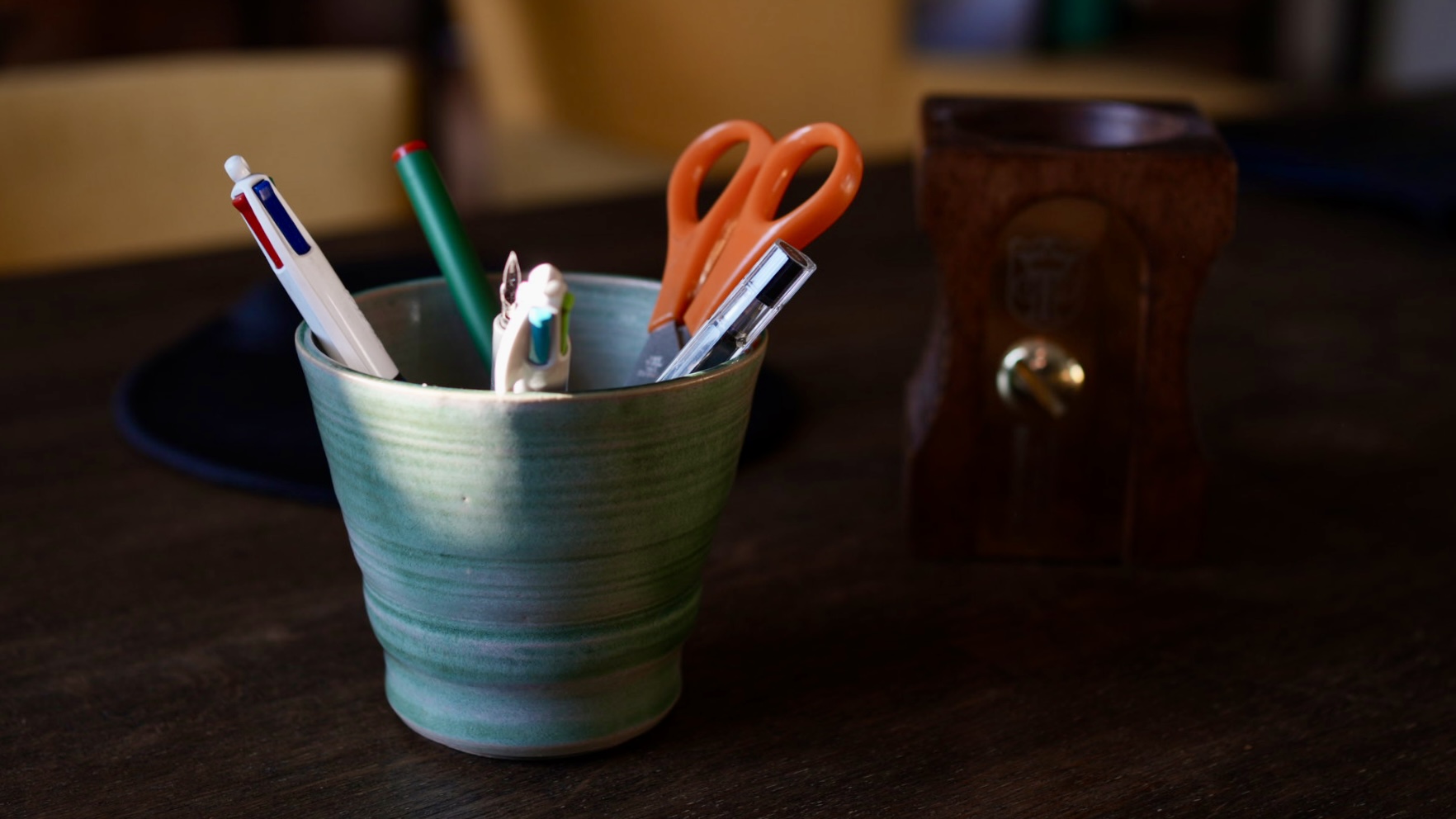 Une tasse détournée en pot à crayon sur un bureau.