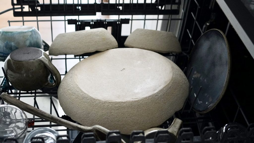 Plusieurs pièces en céramique artisanale dans le lave-vaisselle.