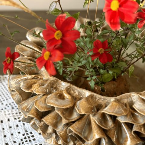 Vue de dessus de vase ÉMILE en céramique artisanale, avec des fleurs piquées dans le dôme visible à l'intérieur.