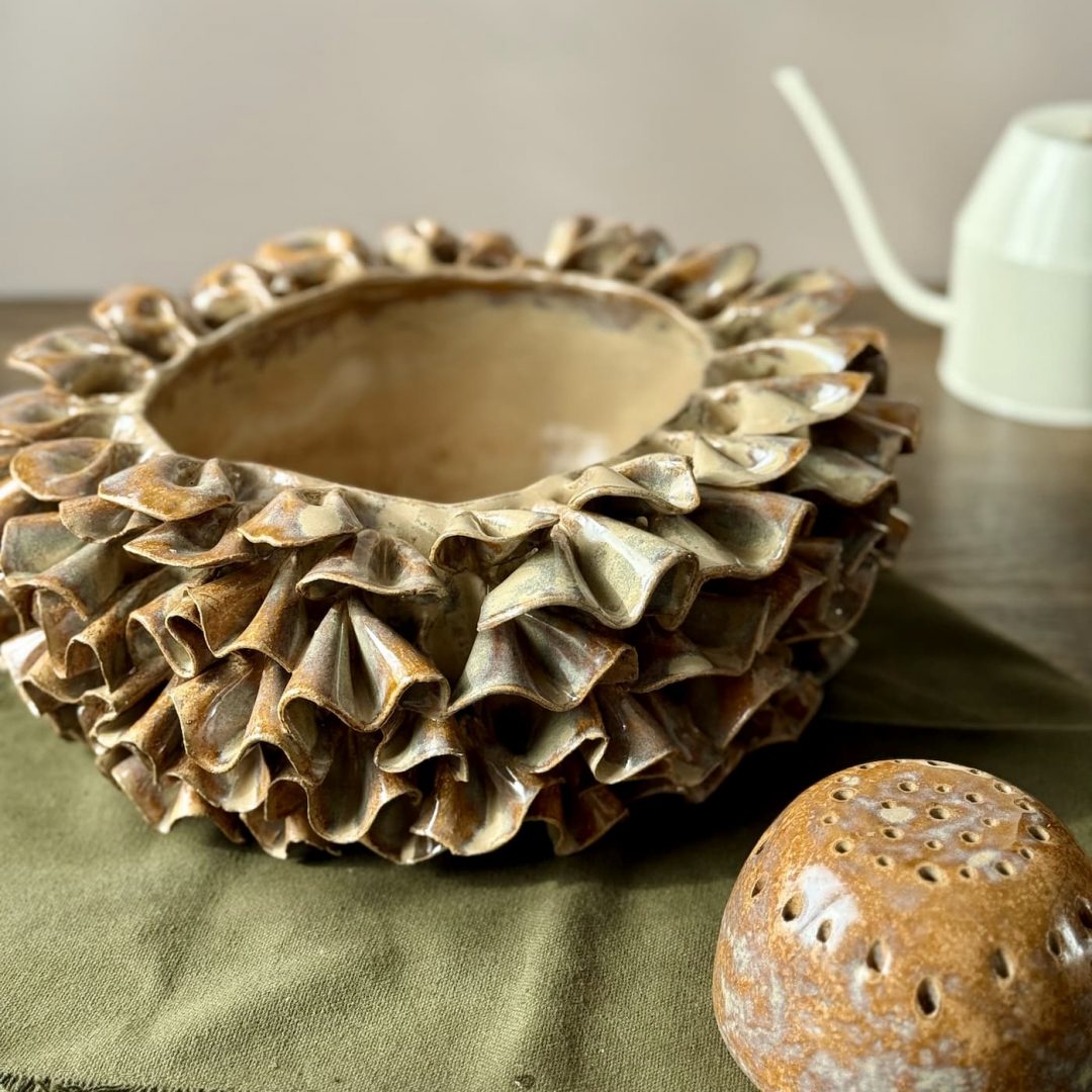 Vase ÉMILE en céramique artisanale avec son dôme perforé posé à côté, présenté sur une table.