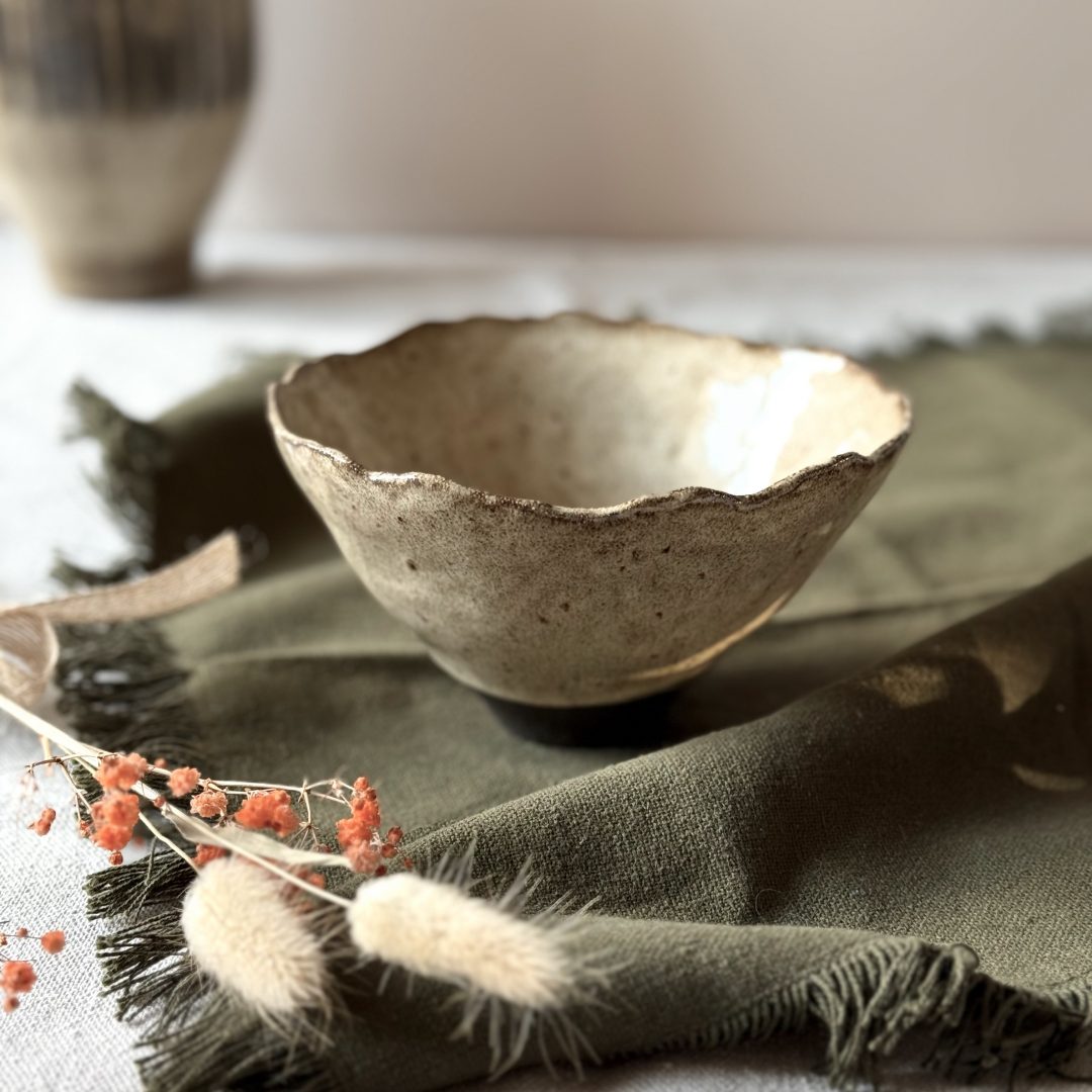 Bol Camellia en grès noir, vue de profil et posée sur une table.