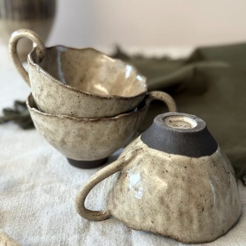 Dessous de la tasse Aster retournée avec la signature de Lis Céramique, posée sur une table, avec d’autres tasses Aster.