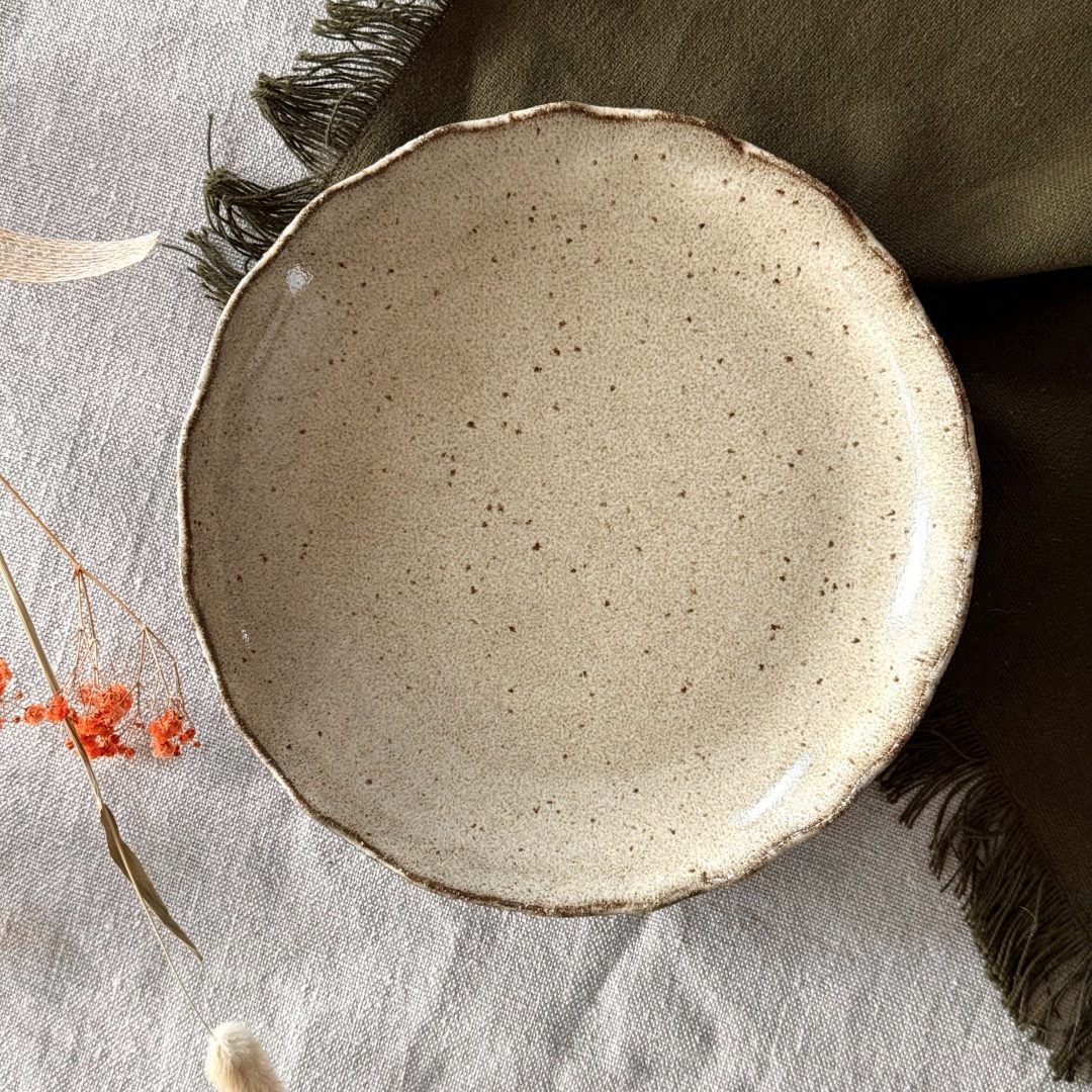 Assiette jasmina vue de dessus en grès noir émaillé crème.