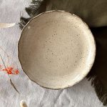 Assiette jasmina vue de dessus en grès noir émaillé crème.