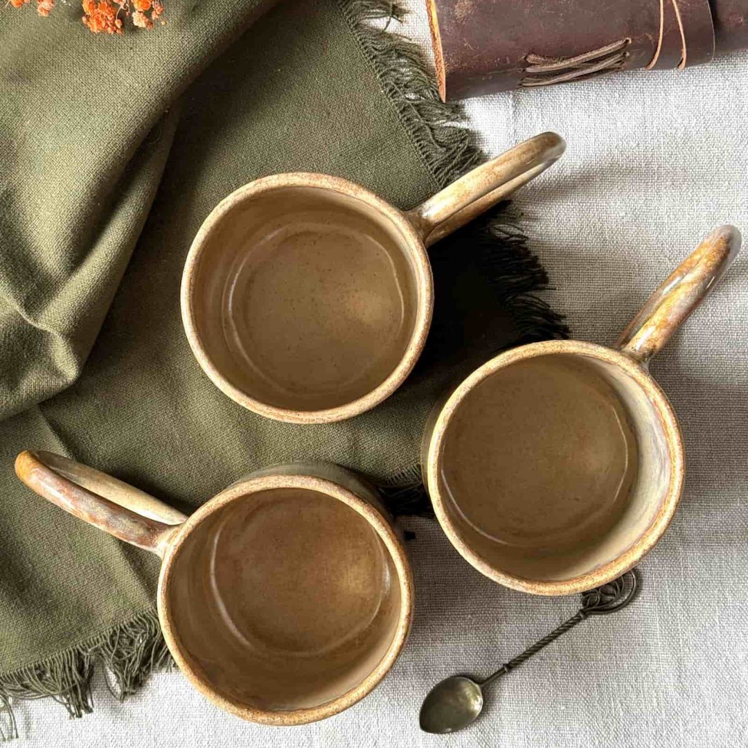 Vue de dessus de trois mugs GARANCE en grès artisanal, posés sur une table.