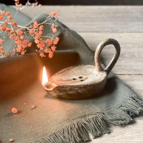 Lampe à huile Stella fait main allumée posée sur une table