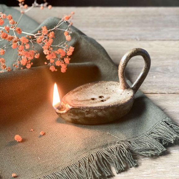 Lampe à huile Stella fait main allumée posée sur une table