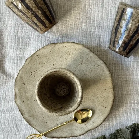 Tasse NAIA posée sur la sous-tasse DAHLIA en céramique artisanale, vue de dessus.
