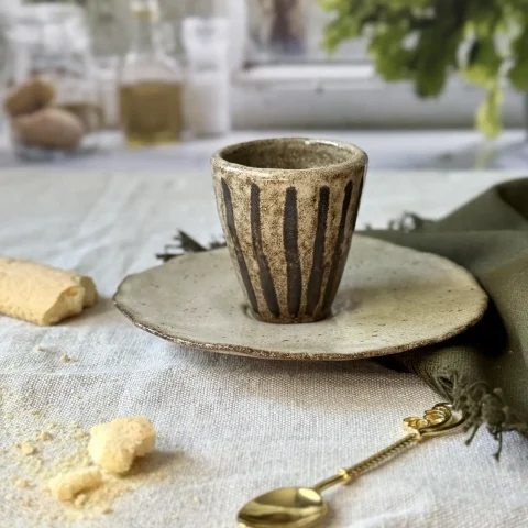 Tasse NAIA posée sur la sous-tasse DAHLIA en céramique artisanale.