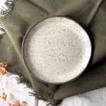 Assiette en grès artisanal crème vue du dessus détail émail pyrité