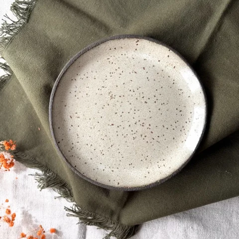 Assiette en grès artisanal crème vue du dessus détail émail pyrité