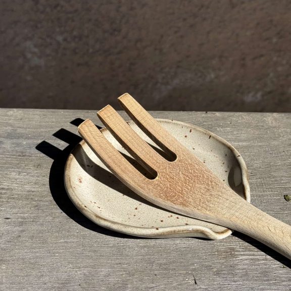 Repose-cuillère Noam en céramique artisanale avec une cuillère dessus.