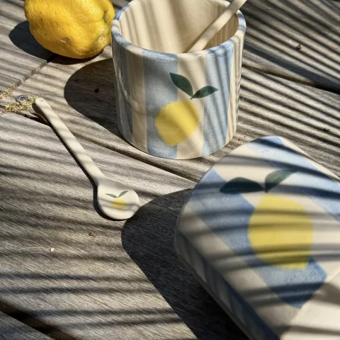Deux tasses citron et 2 cuillères en céramique artisanalea sur une terrasse.