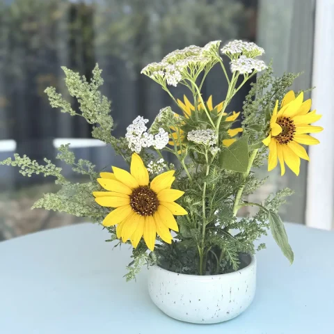 Pique-fleurs ALBA en grès artisanale avec des fleurs posé sur une table.