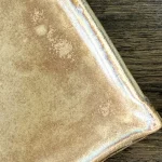 Détail de l'email beige du plat nora en céramique artisanale