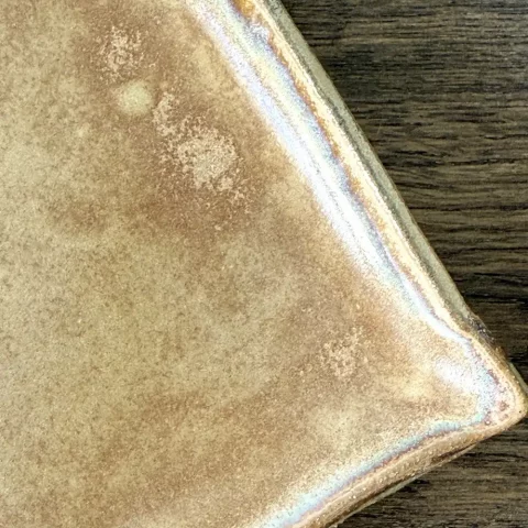 Détail de l'email beige du plat nora en céramique artisanale