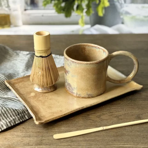 Plat nora avec le support à matcha nori et le mug garance en céramique fait main sur une table
