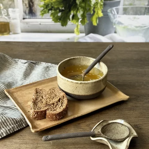 Plat nora avec le bol demba en grès artisanal avec une soupe, la cuillère bintou fait main et la coupelle léa.