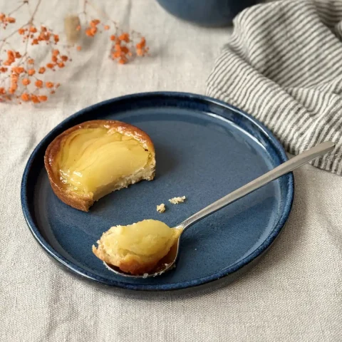 Assiette ELIA en grès bleu profond avec une part de tarte aux pommes.