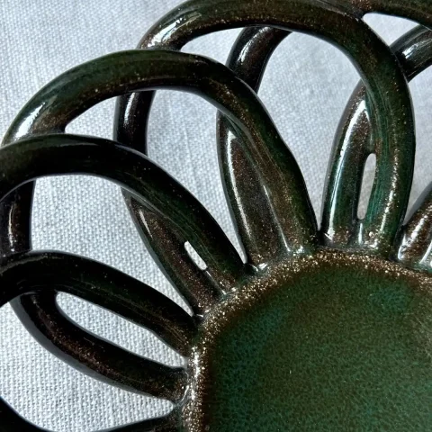 Détail de l'émail vert profond et du décor ajouré de la coupe Zélie.