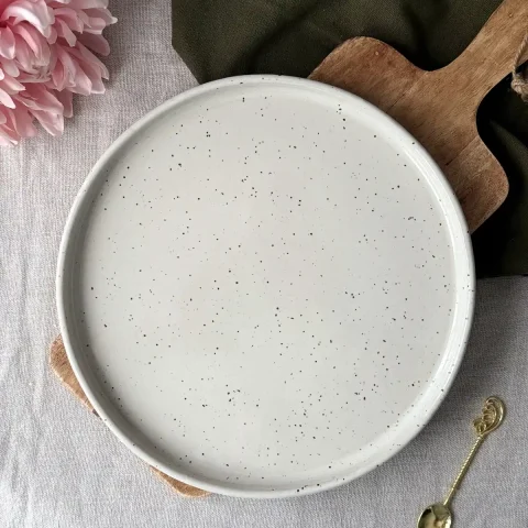 Vu du dessus de la grande assiette ELIA blanc pyrité en grès.