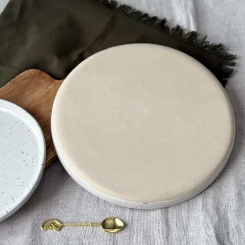 Dessous de la grande assiette ELIA blanc pyrité en grès artisanal.